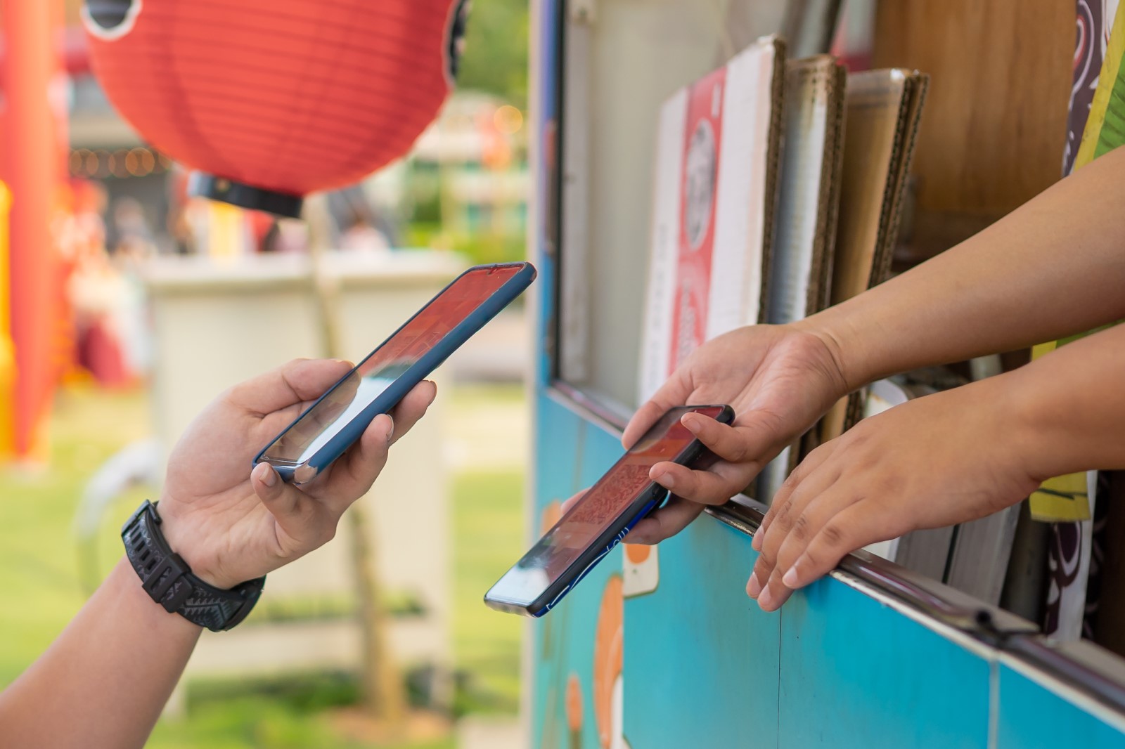 Pessoas fazendo transação pelo celular com tecnologia Bin Tap