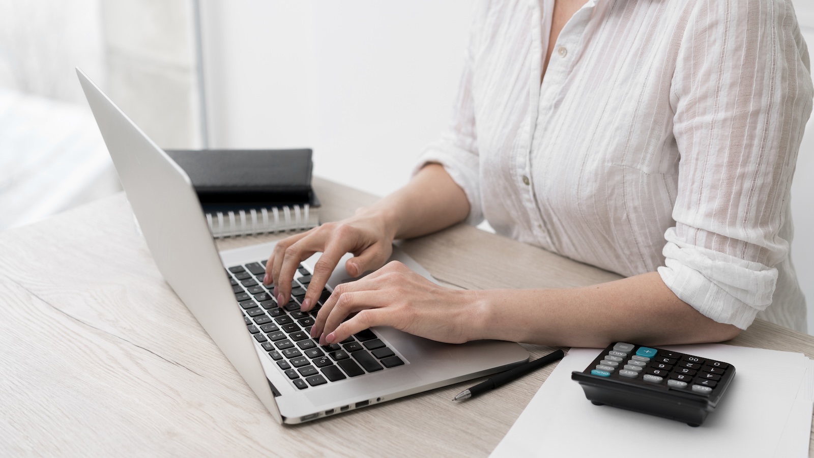 Empreendedora usando o computador para acessar o Menu Recebimentos no Portal Bin